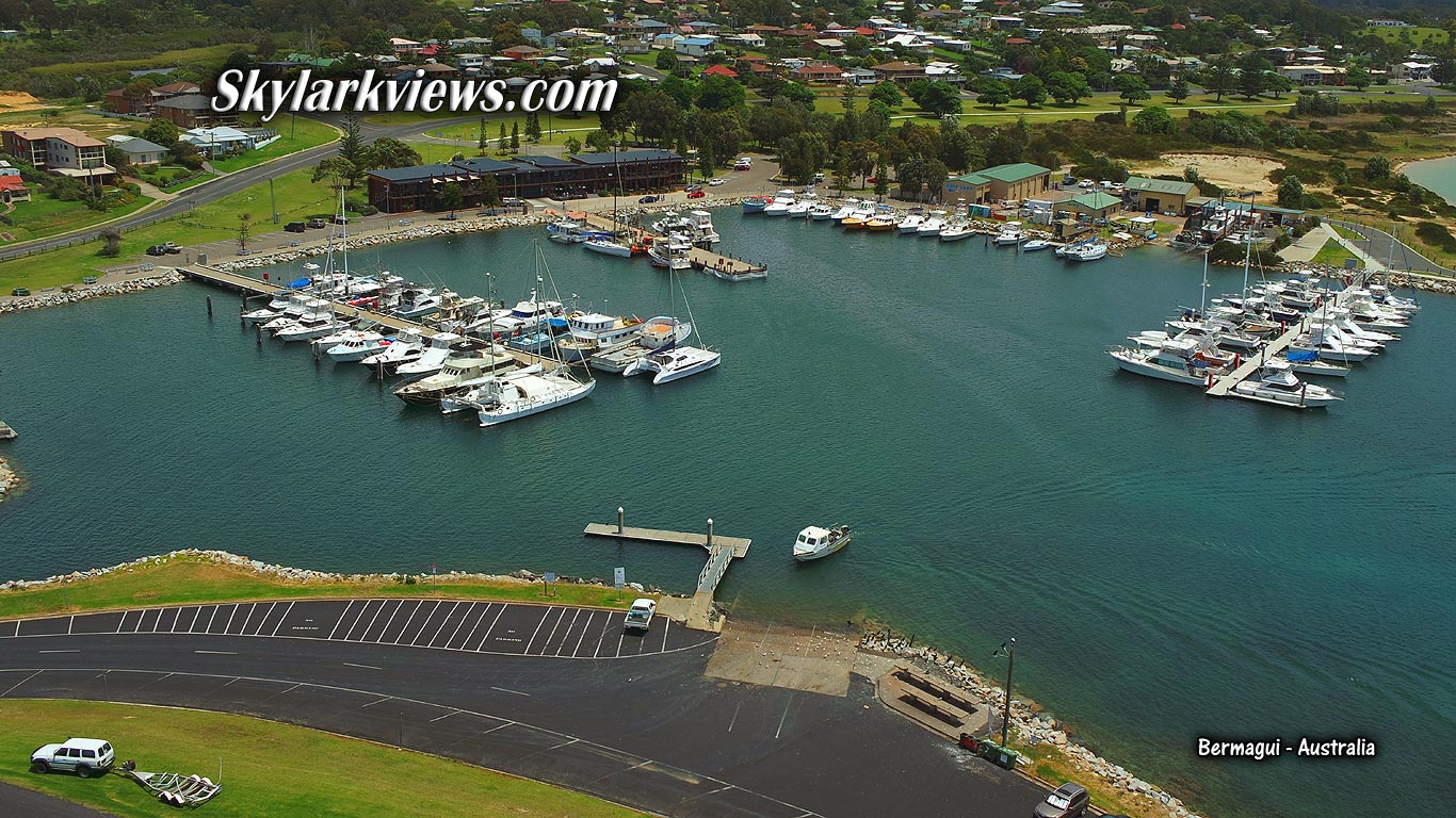 plenty of boats at jetties in harbour seen from above